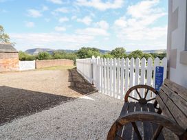 An outdoor area with a wooden bench and gravel at Burgedin Locks Cottage Arddleen near Llandrinio