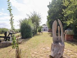An outdoor area with a sculpture and a building at Burgedin Locks Cottage Arddleen near Llandrinio