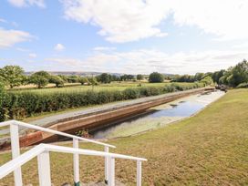 A canal with grass and trees beside it at Burgedin Locks Cottage Arddleen near Llandrinio
