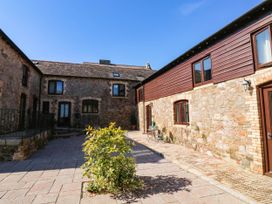 An outdoor area with stone buildings and plants at 3 Town Farm Court in Newton Abbot