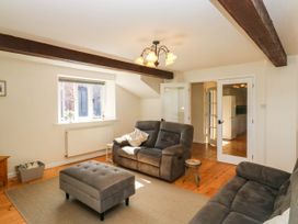 A living room with a couch, ottoman, and window at 3 Town Farm Court Newton Abbot