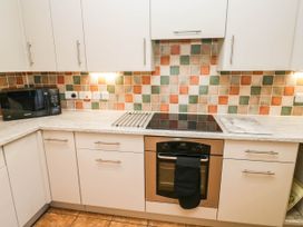 A kitchen with a stove, oven, and microwave at 3 Town Farm Court in Newton Abbot