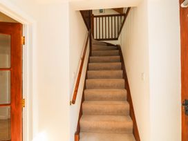A staircase with a handrail and door at 3 Town Farm Court Newton Abbot