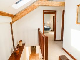 A hallway with a staircase and doors at 3 Town Farm Court in Newton Abbot