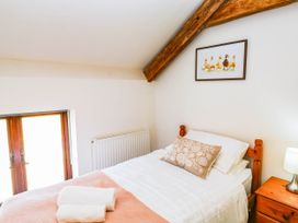 A bedroom with a bed and nightstand at 3 Town Farm Court, Newton Abbot