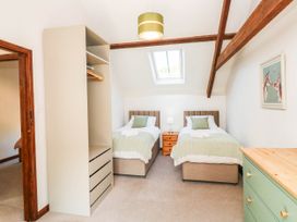A bedroom with two beds and a wardrobe at 3 Town Farm Court in Newton Abbot