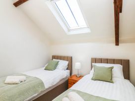 A bedroom with two beds and a skylight at 3 Town Farm Court in Newton Abbot
