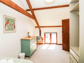 A bedroom with a dresser and chair at 3 Town Farm Court in Newton Abbot