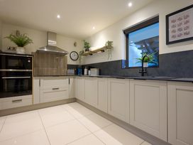 A kitchen featuring cabinets, a sink, oven, and window at Riverside Park 1 Keswick