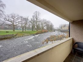 A view of a river and trees from a balcony at Riverside Park 1 in Keswick