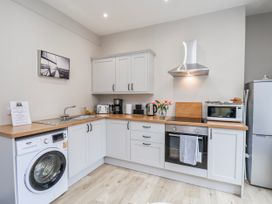 A kitchen with sink, washing machine, and appliances at 24 Baxtergate in Whitby