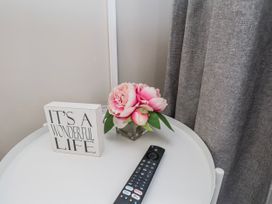 A table with a flower arrangement and a remote control at 24 Baxtergate in Whitby