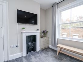A living room with a television, fireplace and window at 24 Baxtergate in Whitby