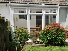 A conservatory with a table and chairs at Sea Spray in Port Isaac