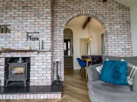 A living room with a fireplace and stairs at Ser a Mor (Stars and Sea) Bull Bay near Amlwch