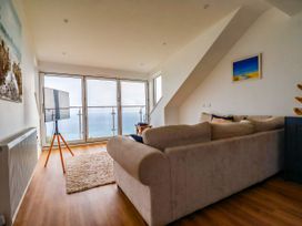 A living room with a sofa and television at 5 St Gwithian Apartments