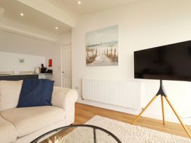 A living room with a television and sofa at 5 St Gwithian Apartments