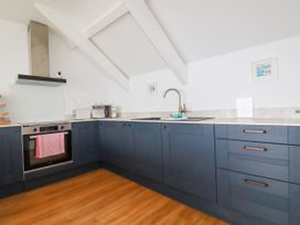 A kitchen with cabinets and appliances at 5 St Gwithian Apartments