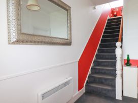 A hallway with a staircase and a mirror at 5 St Gwithian Apartments
