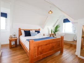 A bedroom with a bed and a bathtub at 5 St Gwithian Apartments