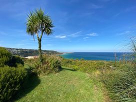 A view of the ocean with a palm tree at 5 St Gwithian Apartments in Carbis Bay