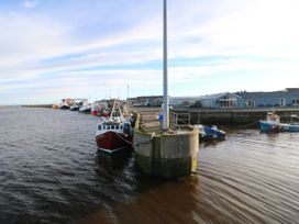 A pier with boats near a dock at Mulberry House in Amble