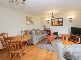 A living room with a sofa and dining area at Low Dow Crag in Coniston