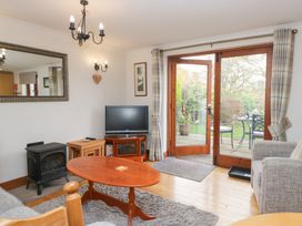 A living room with a television, sofa and coffee table at Low Dow Crag in Coniston