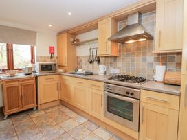 A kitchen with wooden cabinets and appliances at Low Dow Crag in Coniston