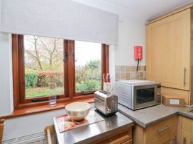 A kitchen with a window, microwave, and toaster at Low Dow Crag in Coniston