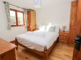 A bedroom with a bed and wooden furniture at Low Dow Crag in Coniston