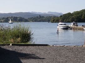 A water scene with boats and a person on a paddle board at Low Dow Crag in Coniston