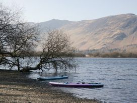 A lake with kayaks and mountains in the background at Low Dow Crag in Coniston