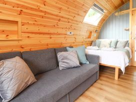 A room with a gray sofa and pillows and a bed with white bedding and pillows at Mallard View in Cockerham near Lancaster