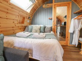 A bedroom with a double bed towels and pillows wooden walls and ceiling a mirror door and robes at Mallard View in Cockerham near Lancaster