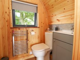 A bathroom with a toilet sink cabinet and window with view of trees at Mallard View in Cockerham near Lancaster
