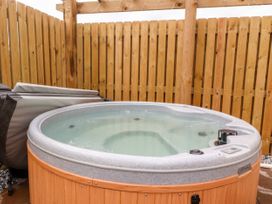 A hot tub filled with water next to a wooden fence at Mallard View in Cockerham near Lancaster