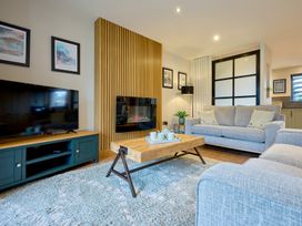 A living room with a television, sofa, and coffee table at Riverside Park 3 in Keswick