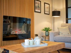 A living room with a coffee table, sofa and fireplace at Riverside Park 3 in Keswick