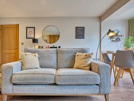 A living room with a sofa and a dining area at Riverside Park 3 in Keswick