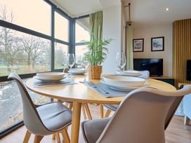 A dining room with a round table set for meals at Riverside Park 3 in Keswick