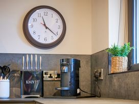 A kitchen with a clock and coffee maker at Riverside Park 3 in Keswick