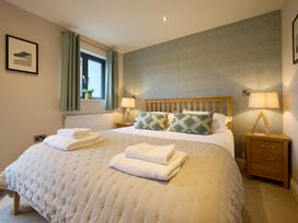 A bedroom with a bed and bedside table at Riverside Park 3 in Keswick