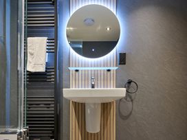 A bathroom with a washbasin and a mirror at Riverside Park 3 in Keswick