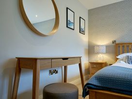 A bedroom with a bed, desk, and lamp at Riverside Park 3 in Keswick