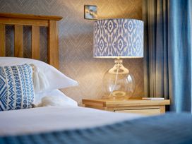 A bedroom with a lamp on a bedside table at Riverside Park 3 in Keswick