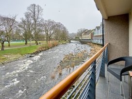 A river flowing near buildings and trees at Riverside Park 3 in Keswick