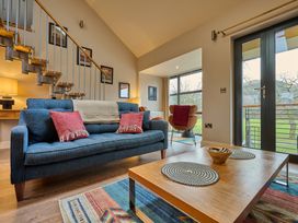 A living room featuring a sofa, coffee table, and staircase at Riverside Park 5 in Keswick
