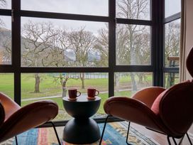 A cozy living room with chairs and a view of trees at Riverside Park 5 in Keswick