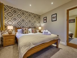A bedroom with a bed and nightstand at Riverside Park 5 in Keswick